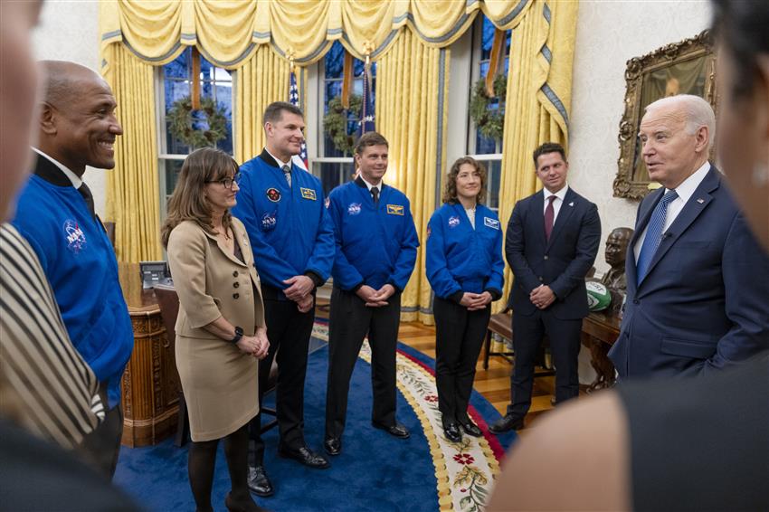 Les astronautes et quelques membres de leur famille discutent avec Joe Biden dans le Bureau ovale.