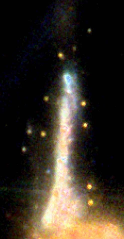 Gros plan de la galaxie Sparkler, où l'on voit tout autour plusieurs amas globulaires et groupes stellaires.