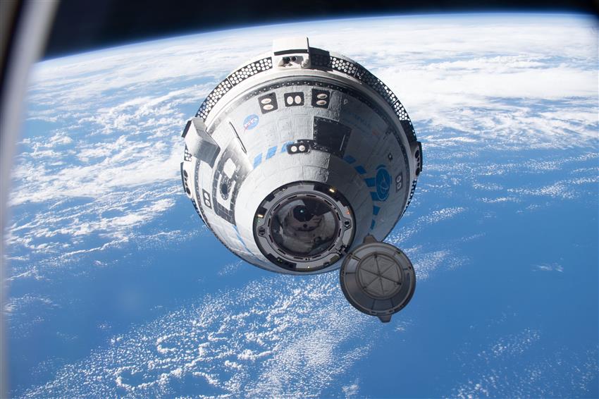 The CST-100 Starliner spacecraft in space over the South Pacific.